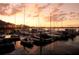 Beautiful marina at sunset with sail boats docked, silhouetted by an orange and pink sky at 9346 San Jose Blvd, Howey In The Hills, FL 34737