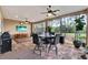 Screened patio featuring tile flooring, ceiling fans, a bar height table and an outdoor dining table at 9346 San Jose Blvd, Howey In The Hills, FL 34737