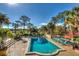 Luxurious community pool surrounded by lounge chairs and tropical landscaping at 9346 San Jose Blvd, Howey In The Hills, FL 34737