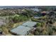 Aerial view of multiple tennis courts surrounded by lush greenery, perfect for an active lifestyle at 9346 San Jose Blvd, Howey In The Hills, FL 34737