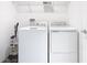 Well-lit laundry area equipped with modern washer, dryer, and storage shelves at 942 Jackson Ave, Davenport, FL 33837