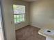 A small, carpeted living room with a large window and counter at 1013 S Hiawassee Rd # 3626, Orlando, FL 32835