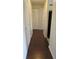 Hallway with sleek hardwood floors and white paneled doors to closets, leading to other rooms at 1083 S Hiawassee Rd # 635, Orlando, FL 32835