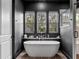 Bathroom boasts a soaking tub under bright windows, complemented by dark walls and tile at 1091 Eaglecrest Dr, Winter Garden, FL 34787