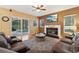 Inviting living room featuring a fireplace, ceiling fan, and sliding glass doors to the pool at 1232 Scandia Ter, Oviedo, FL 32765