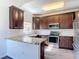 Well-equipped kitchen with granite countertops, stainless steel appliances, and dark wood cabinets at 124 Meridian Ave, Kissimmee, FL 34759