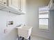Bright laundry room with white cabinets, utility sink, neutral tile flooring, and a window at 124 Meridian Ave, Kissimmee, FL 34759