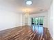 Bright living room featuring wood floors, a modern light fixture, and sliding glass doors to the outside at 124 Meridian Ave, Kissimmee, FL 34759