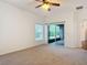 Carpeted main bedroom with ceiling fan, sliding glass doors to the outside and window at 124 Meridian Ave, Kissimmee, FL 34759