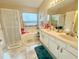 Bright bathroom with a double vanity, soaking tub, and glass shower with a large window at 13440 Fordwell Dr, Orlando, FL 32828