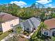 An aerial view of the home and screened in pool set among lush, mature trees at 151 Castaway Beach Way, Kissimmee, FL 34746