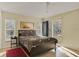 Bright bedroom with tile floors, a queen bed with floral comforter, and sliding glass doors to the patio at 151 Castaway Beach Way, Kissimmee, FL 34746