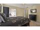 Comfortable bedroom featuring neutral walls, sliding glass doors, and a queen bed with floral comforter at 151 Castaway Beach Way, Kissimmee, FL 34746