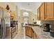 Bright kitchen featuring stainless steel appliances, tile backsplash, and a breakfast bar at 151 Castaway Beach Way, Kissimmee, FL 34746