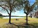 Well-maintained backyard with trees and picnic tables overlooking a serene lake at 1552 Broken Oak Dr # B, Winter Garden, FL 34787