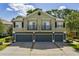 A modern exterior elevation of a townhome showing the garages and balconies on a sunny day at 1552 Broken Oak Dr # B, Winter Garden, FL 34787