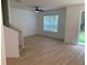 Bright living room featuring light wood floors, a modern ceiling fan, and large windows showcasing a peaceful view at 1552 Broken Oak Dr # B, Winter Garden, FL 34787