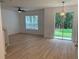 Bright living room featuring light wood floors, a modern ceiling fan, and sliding glass doors that lead to the backyard at 1552 Broken Oak Dr # B, Winter Garden, FL 34787