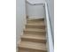 A well-lit staircase featuring wood steps and white railings that creates an open and inviting atmosphere to the home at 1552 Broken Oak Dr # B, Winter Garden, FL 34787