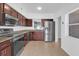 Modern kitchen featuring stainless steel appliances, granite countertops, and dark wood cabinets at 1725 Marcia Dr, Orlando, FL 32807