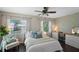 Bright bedroom with a ceiling fan, a desk with chair, and large windows at 1815 6Th Se St, Winter Haven, FL 33880