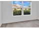Bright bedroom with light wood floors and a large window offering neighborhood views at 1959 Keel Ct, The Villages, FL 34762