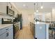 Modern kitchen features a breakfast bar, stainless steel appliances, sleek cabinetry, and hardwood floors at 1959 Keel Ct, The Villages, FL 34762
