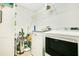 Functional laundry room featuring a washer, dryer, storage shelves, and cleaning supplies at 1959 Keel Ct, The Villages, FL 34762