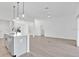 Bright and spacious living room with wood-look floors, flowing to a kitchen with center island at 1959 Keel Ct, The Villages, FL 34762