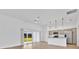 Bright living room featuring sliding glass doors to the yard and an open floor plan to the modern kitchen at 1959 Keel Ct, The Villages, FL 34762
