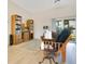 Bright living room showcases wood flooring, a comfortable sitting area, and a large window with a backyard view at 1959 Keel Ct, The Villages, FL 34762