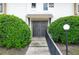 Close-up of a condo entrance featuring double doors, a walkway, and manicured bushes at 200 Maitland Ave # 86, Altamonte Springs, FL 32701