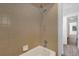 A beige tiled shower/tub area with a handheld shower head is featured in this bathroom at 20240 Sw 95Th St, Dunnellon, FL 34431