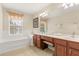 Bright bathroom with soaking tub, wood vanity with double sinks and tiled floor at 2508 Archfeld Blvd, Kissimmee, FL 34747