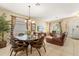 Dining area with a round glass-top table, chandelier lighting, and direct access to the living room at 2508 Archfeld Blvd, Kissimmee, FL 34747