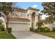 Two-story home featuring a two car garage, neutral colored stucco, tile roof, and well-maintained landscaping at 2508 Archfeld Blvd, Kissimmee, FL 34747