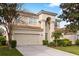 Beautiful two-story home displaying lush landscaping, a barrel tile roof, and an attached two-car garage at 2508 Archfeld Blvd, Kissimmee, FL 34747