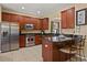Updated kitchen features stainless steel appliances, granite countertops, and rich wood cabinetry at 2508 Archfeld Blvd, Kissimmee, FL 34747