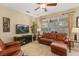 Relaxing living room featuring a large window, leather seating, entertainment center, and neutral decor at 2508 Archfeld Blvd, Kissimmee, FL 34747