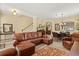 Spacious living room featuring an open concept, tile floors, comfortable leather furnishings, and decorative accents at 2508 Archfeld Blvd, Kissimmee, FL 34747