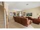 Bright living room showcasing tile floors, comfortable leather seating, staircase, and a media center at 2508 Archfeld Blvd, Kissimmee, FL 34747
