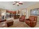 Open-concept living area featuring tile floors, cherry wood cabinets, stainless appliances and comfortable leather seating at 2508 Archfeld Blvd, Kissimmee, FL 34747