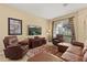 Inviting living area with leather furnishings, neutral tones, and a window offering natural light and outdoor views at 2508 Archfeld Blvd, Kissimmee, FL 34747