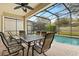 Covered patio with an outdoor dining table and view of the pool at 2508 Archfeld Blvd, Kissimmee, FL 34747