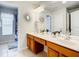 Bathroom features double vanity, wood cabinets, large mirror and views to toilet and shower at 2548 Archfeld Blvd, Kissimmee, FL 34747