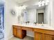 Bathroom with double vanity, wood cabinets, large mirror and wall decor at 2548 Archfeld Blvd, Kissimmee, FL 34747
