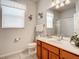 A well-lit bathroom with a vanity, toilet, and shower featuring tiled flooring at 2548 Archfeld Blvd, Kissimmee, FL 34747