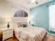 Cozy bedroom with a queen bed, stylish lamps, and a unique geometric art display at 2548 Archfeld Blvd, Kissimmee, FL 34747