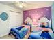 A bedroom features two twin beds with Frozen themed bedding and snowflake decals on the walls at 2548 Archfeld Blvd, Kissimmee, FL 34747