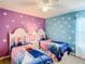 A bedroom features beds with Frozen themed comforters and snowflake decals on the walls at 2548 Archfeld Blvd, Kissimmee, FL 34747